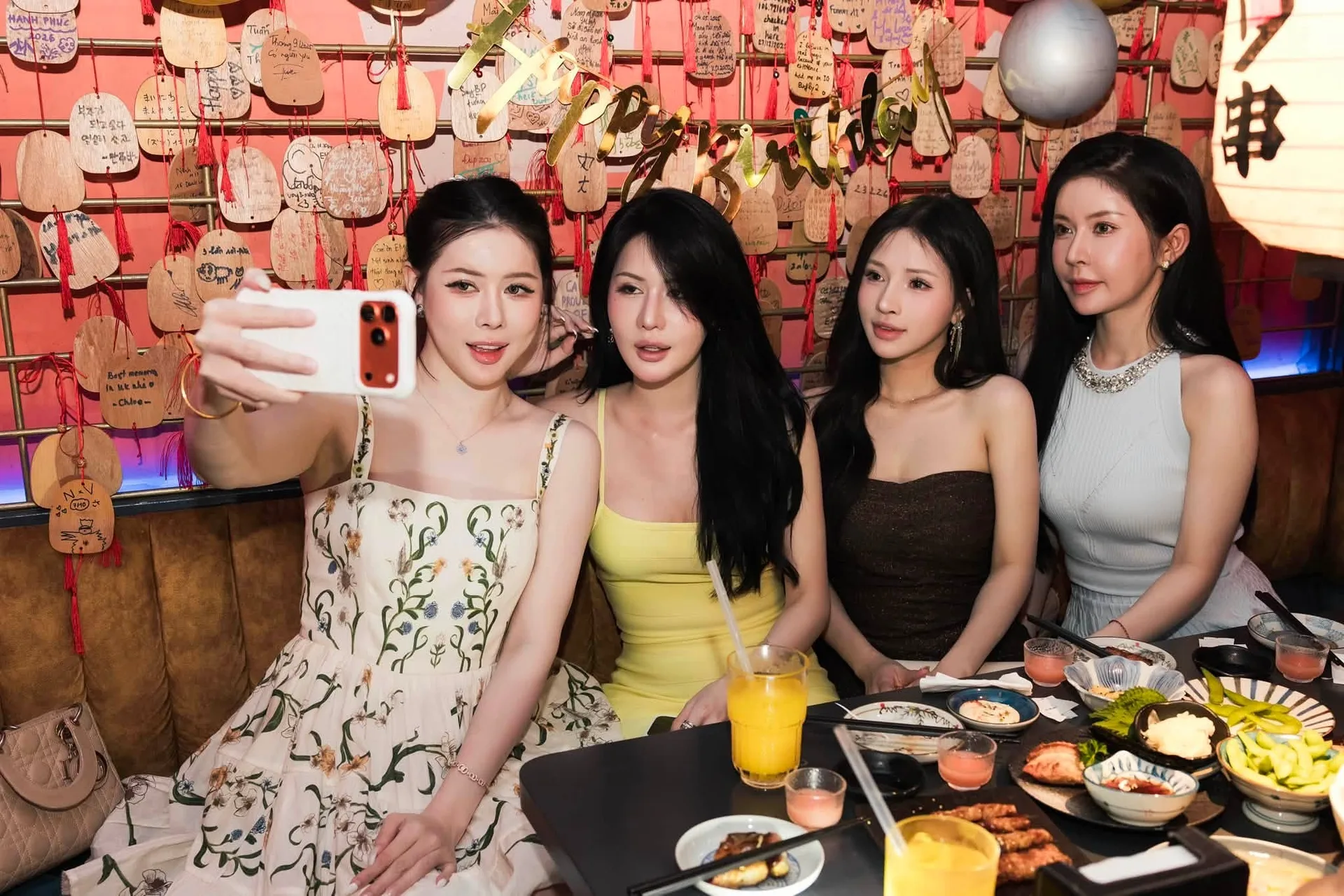 EMOI Hà Nội — nhóm bạn chụp ảnh trước tường thẻ gỗ ema