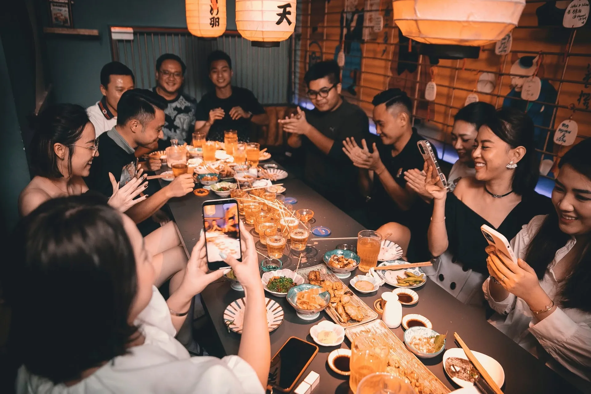 Hội bạn quây bàn dài dưới đèn lồng giấy tại EMOI